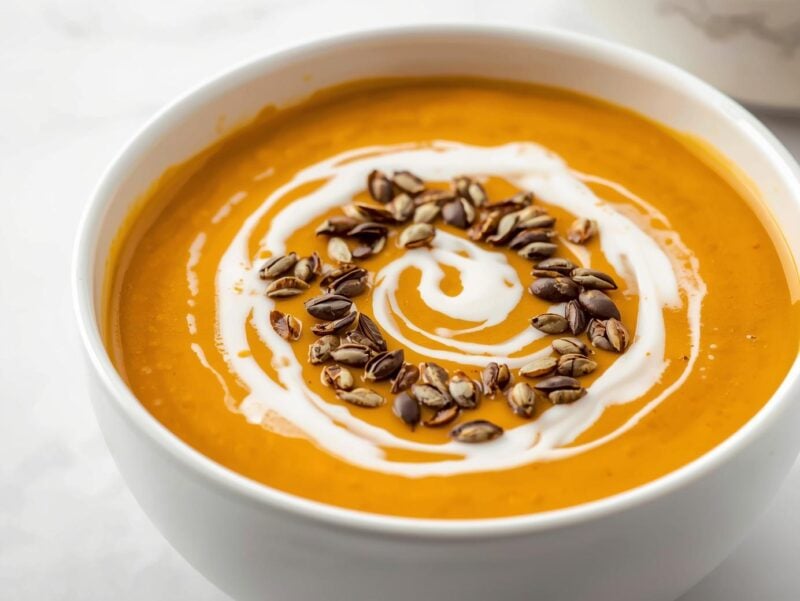 Butternut squash soup with a swirl of cream and toasted pumpkin seeds on top