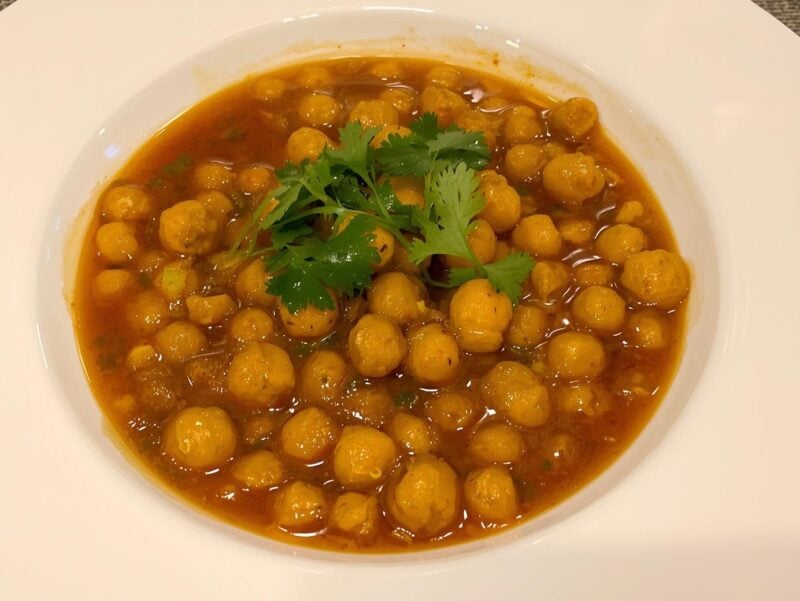 Chana Masala with chickpeas in a spiced tomato sauce garnished with cilantro, a vegan option in 10 Indian curry recipes