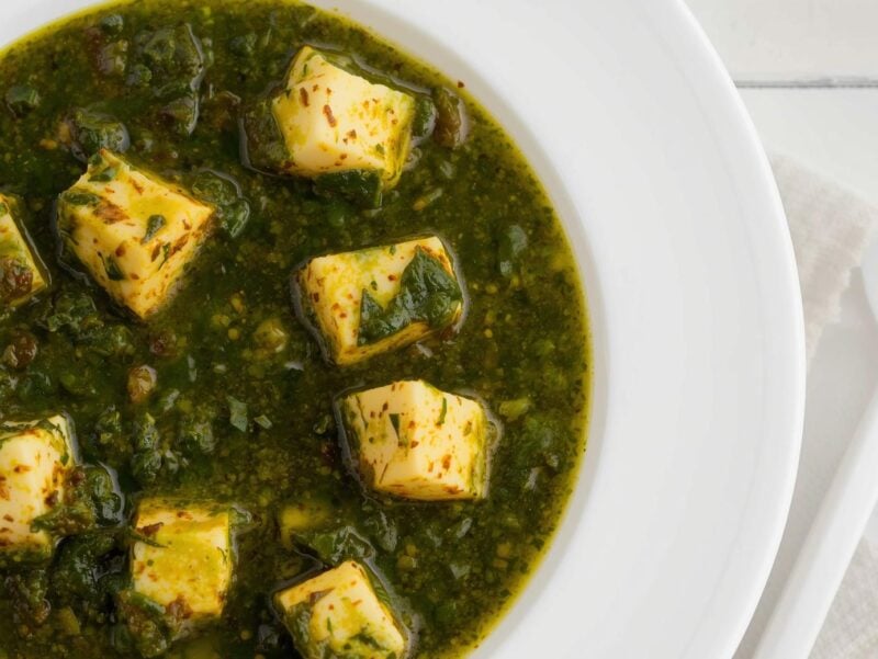 Saag Paneer with cubes of paneer cheese in a vibrant green spinach sauce, a vegetarian option in 10 Indian curry recipes