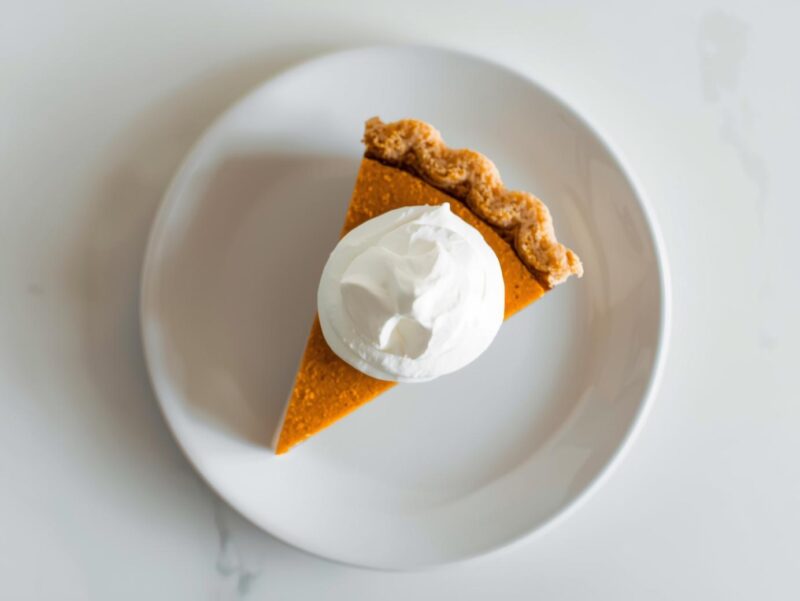 Slice of vegan pumpkin pie with coconut whipped cream