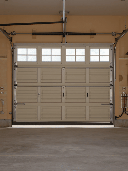 Start With a Garage Door Inspection
Close the garage door and inspect it from inside during daylight. Look for narrow lines of light around the edges or underneath the door. These gaps often reveal where cold air, dust, rain, insects, and small pests are getting inside.
Check the following areas:
The bottom seal
Side weatherstripping
The top seal
The floor beneath the door
Door panels and hinges
Springs, rollers, and tracks
The interior insulation
Also open and close the door several times. Listen for scraping, grinding, rattling, or sudden jerking. A door that is difficult to operate may need mechanical attention before you add insulation or new seals.
Do not work on garage door springs or cables unless you are trained to do so. These components are under significant tension and can cause serious injury.